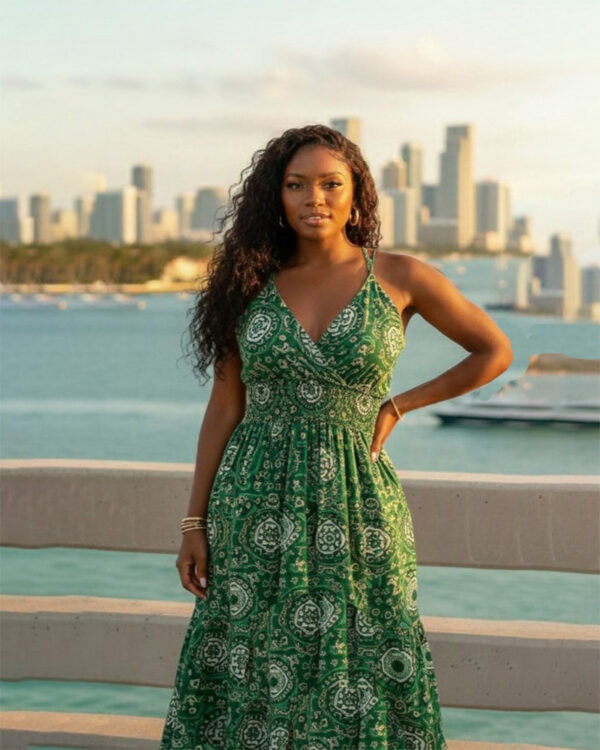 Woman with curly hair wearing a blue paisley tiered boho maxi dress with a V-neck and smocked waist