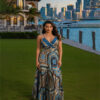 Woman with curly hair wearing a blue paisley tiered boho maxi dress with a V-neck and smocked waist