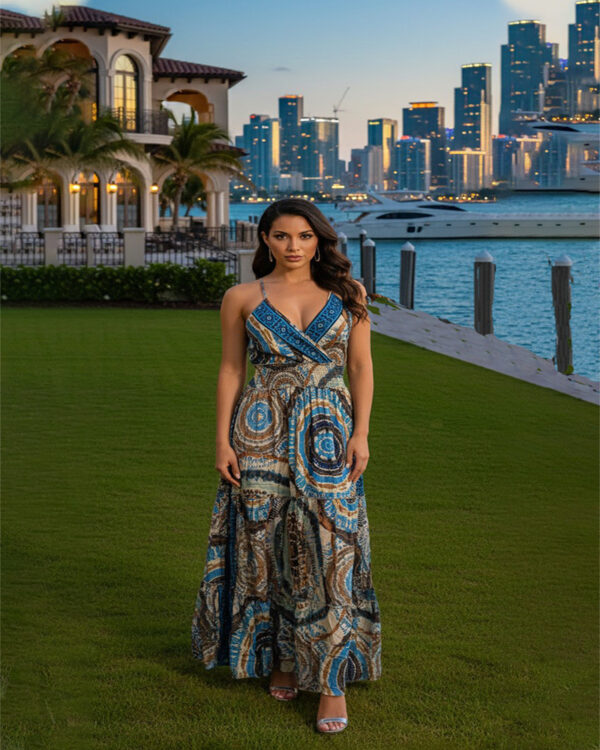Woman with curly hair wearing a blue paisley tiered boho maxi dress with a V-neck and smocked waist