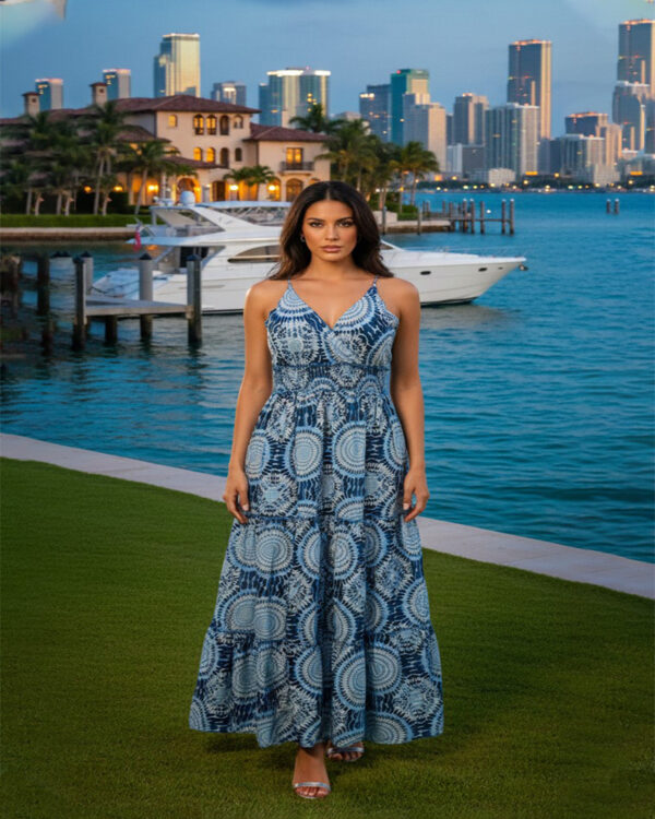 Woman with curly hair wearing a blue paisley tiered boho maxi dress with a V-neck and smocked waist